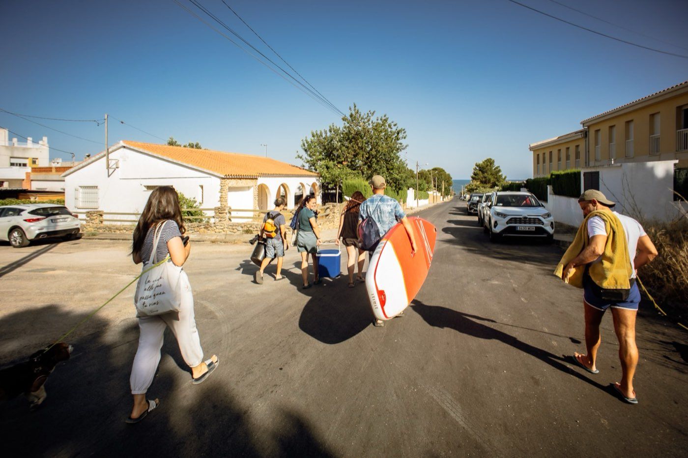 La tribu saliendo de casa hacia la playa con el paddle